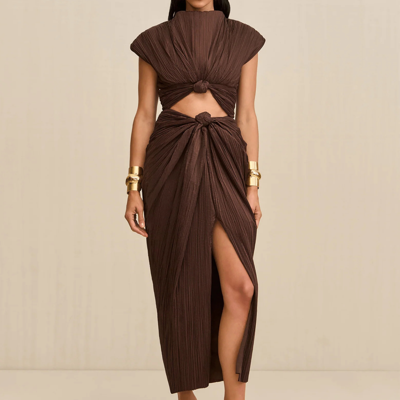 Brown dress with cut-out design and gold accessories on a beige background